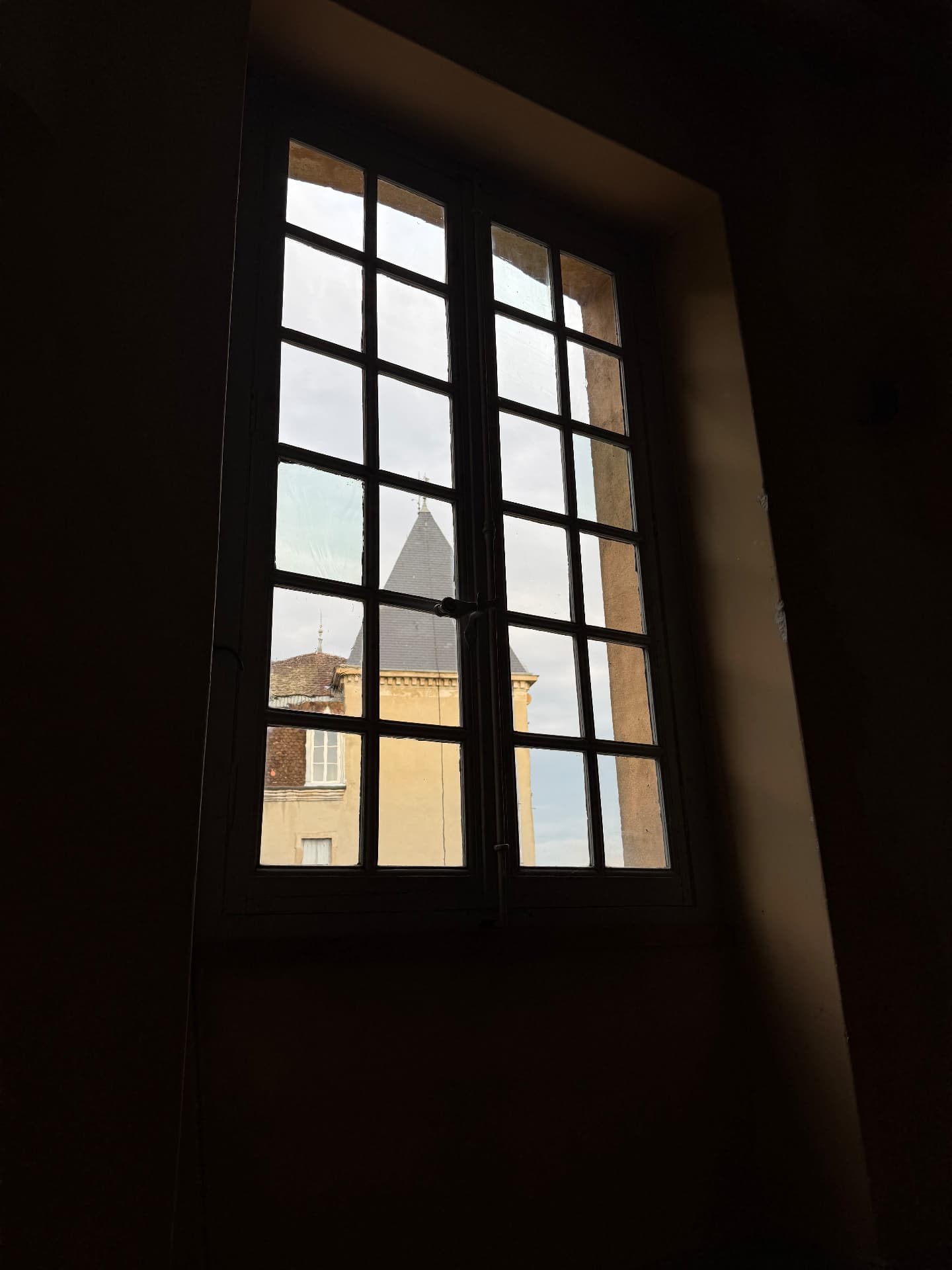 Le clocheton du château vu depuis une fenêtre à petits carreaux